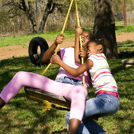 two girls on a tire swing